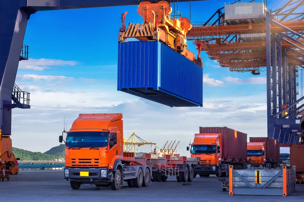 Container trucks under a port crane in the UAE